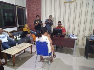 Herlina Mondo menggendong bayinya saat melapor ke Polres Bolmong
