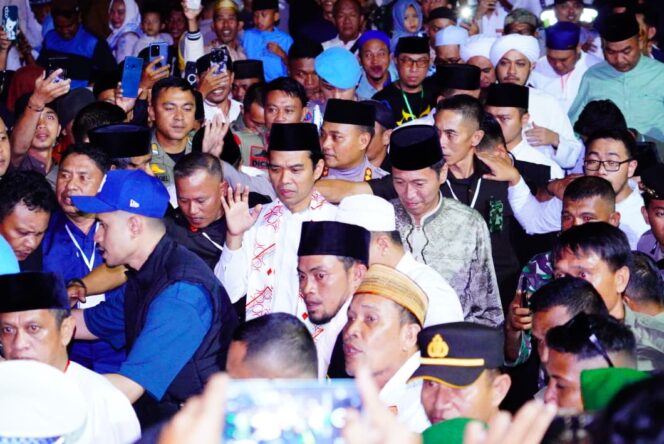 
Bupati Bolsel Iskandar Kamaru dan Ustadz Abdul Somad di tengah kerumunan warga yang mengikuti tabligh akbar.